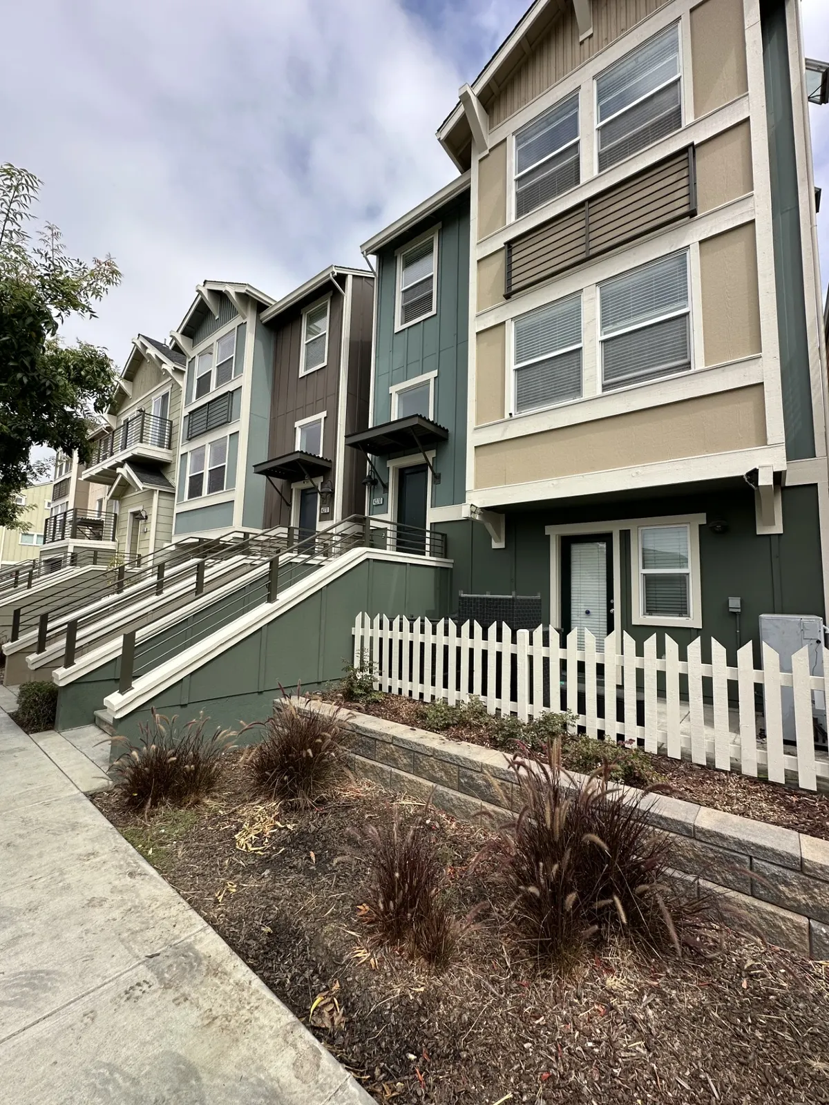 Townhome community repainted in green, tan, and red with white trim