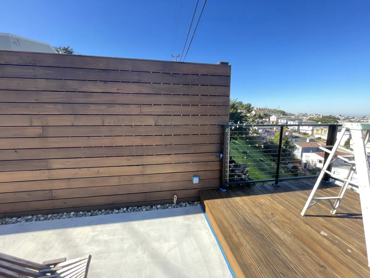 Rooftop deck with a stained horizontal wood privacy fence