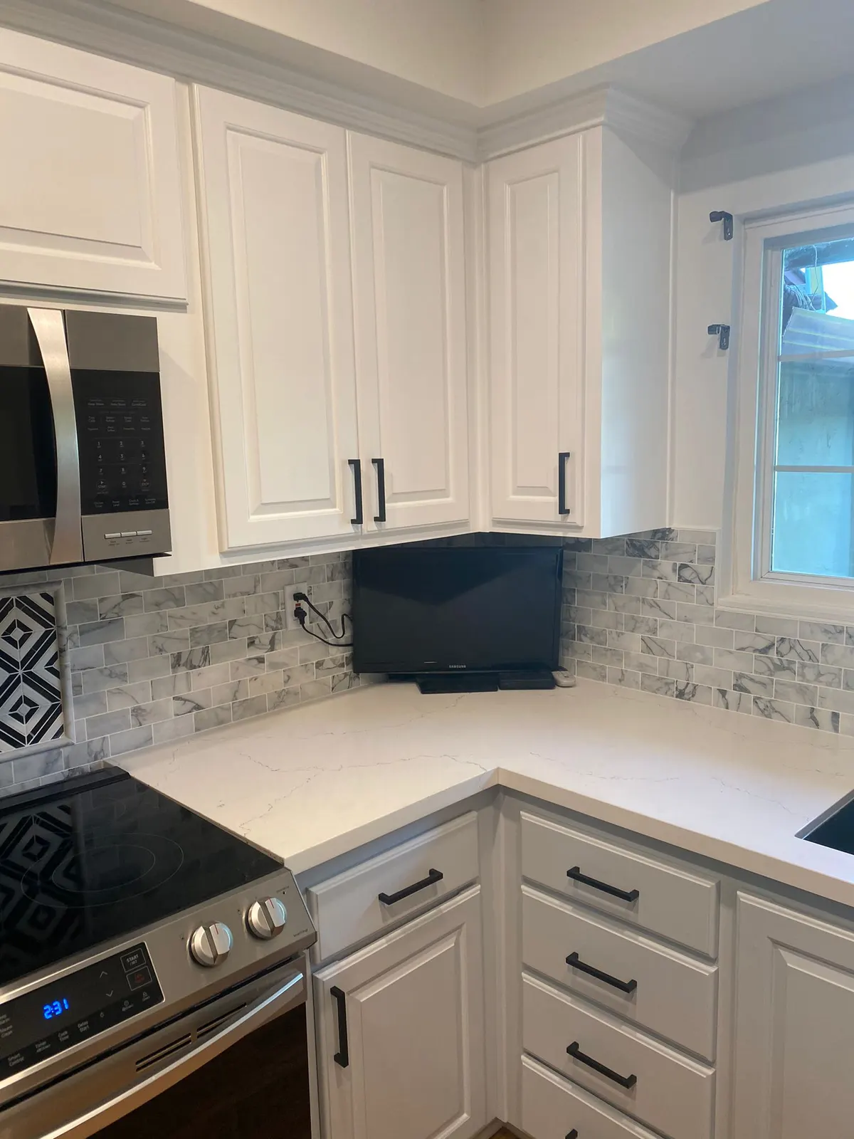 Kitchen with white upper cabinets and gray lower cabinets after refinishing