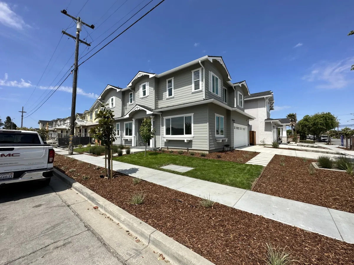 Row of new two-story homes with gray siding and white trim