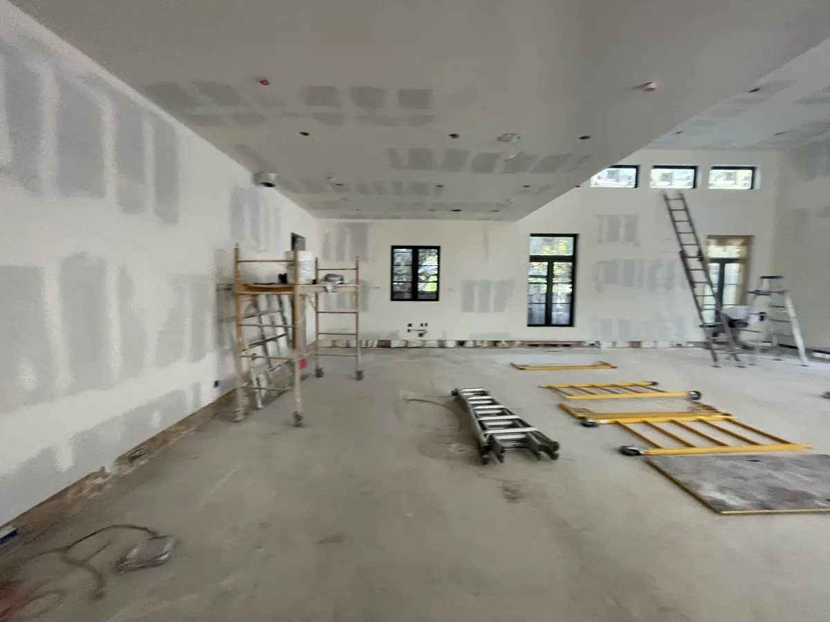 Open room with newly hung and taped sheetrock walls and ceiling